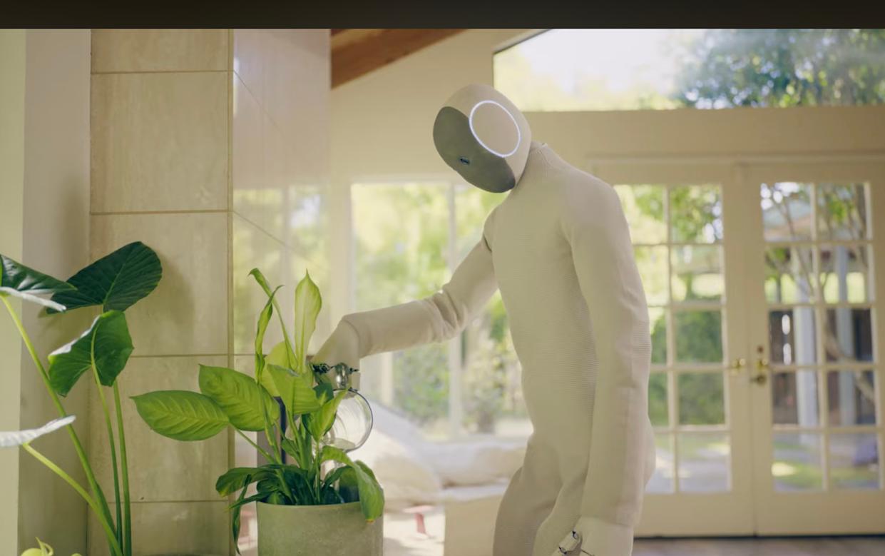 NEO humanoid robot by 1X Technologies watering a houseplant inside a modern living room, showcasing home assistance and everyday task automation